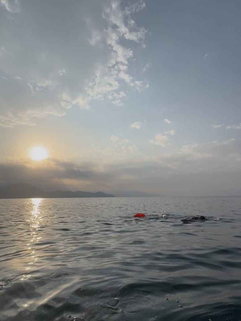 Open-water swimming across Lake Sevan at dawn